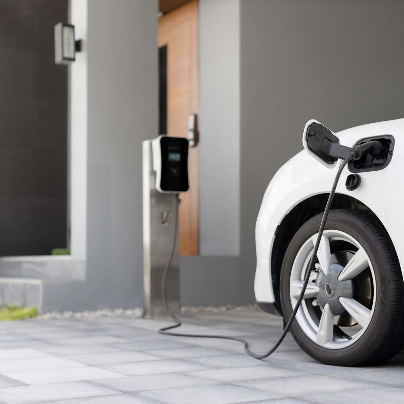 Progressive concept of EV car and home charging station in residential area. Progressive concept of EV car and home charging station powered by sustainable and clean energy with zero CO2 emission for green environmental. Charging point at residential area for electric vehicle.